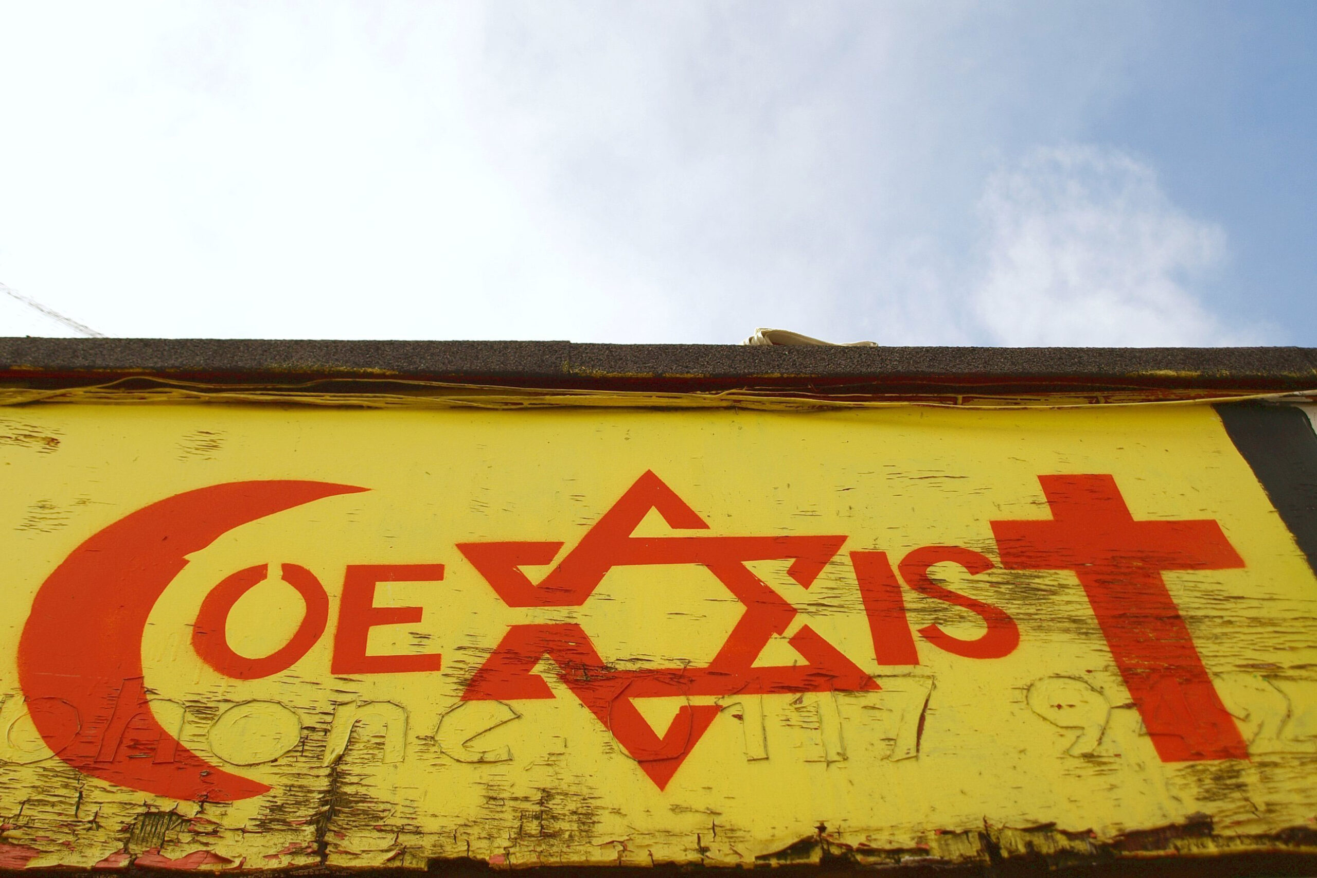 一位身份不明的艺术家在英国布里斯托尔的一座市中心建筑上观看以宗教宽容为主题的涂鸦作品。