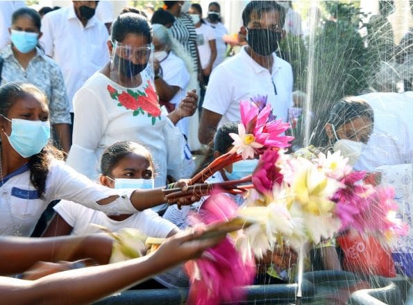 Tempio di Kelaniya 2 bambini bagnano le loro offerte floreali a una fontana. Foto Ajith Perera Xinhua Gli srilankesi festeggiano la prima visita del Buddha sull'isola